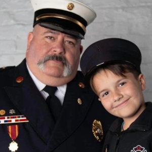 Chief Mike Fronimos and his son shown in Fire Department dress uniforms.